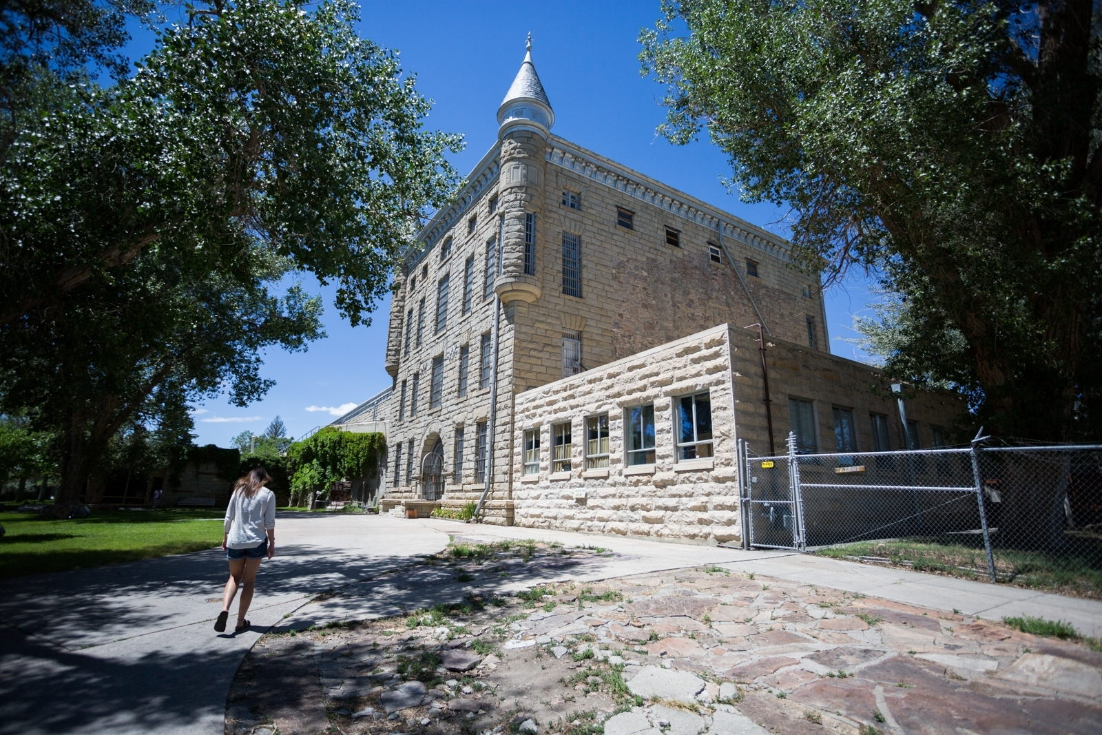 A woman walking into a historic prison building