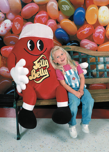 Girl and Jelly Belly character on bench