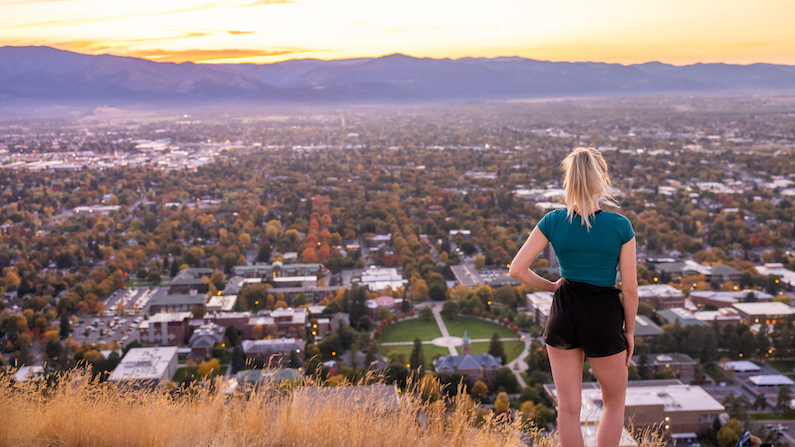 Woman hiking with views of Missoula in autumn
