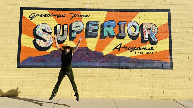 Person jumping in front of mural in Superior, Arizona