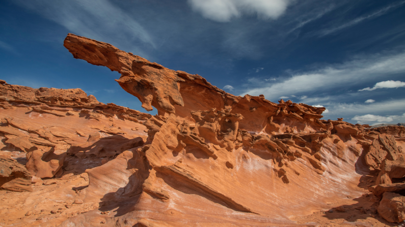 A unique red rock formation jutts out against a blue sky at Gold Butte National Monument