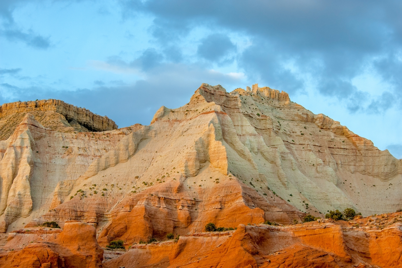 A yellow and orange rocky cliffside at sunset.
