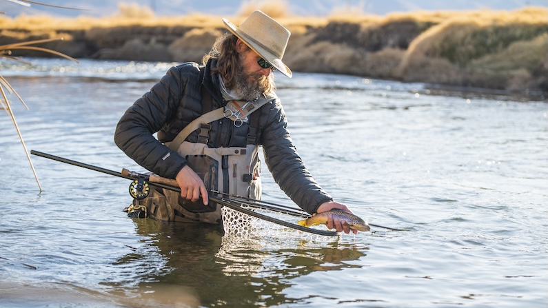 Fisherman holding a fish above net in Bishop California winter