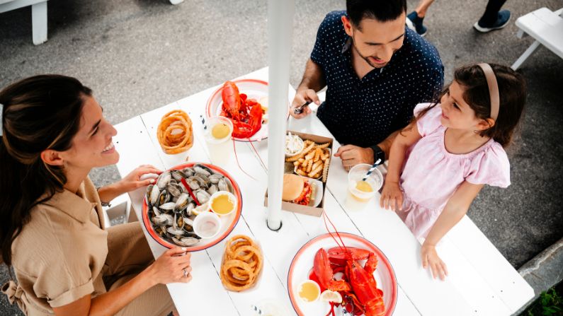 A family eating fresh lobster and oysters in Kennebunkporte, ME.