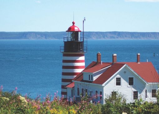 A red and white lighthouse overlooking the sea