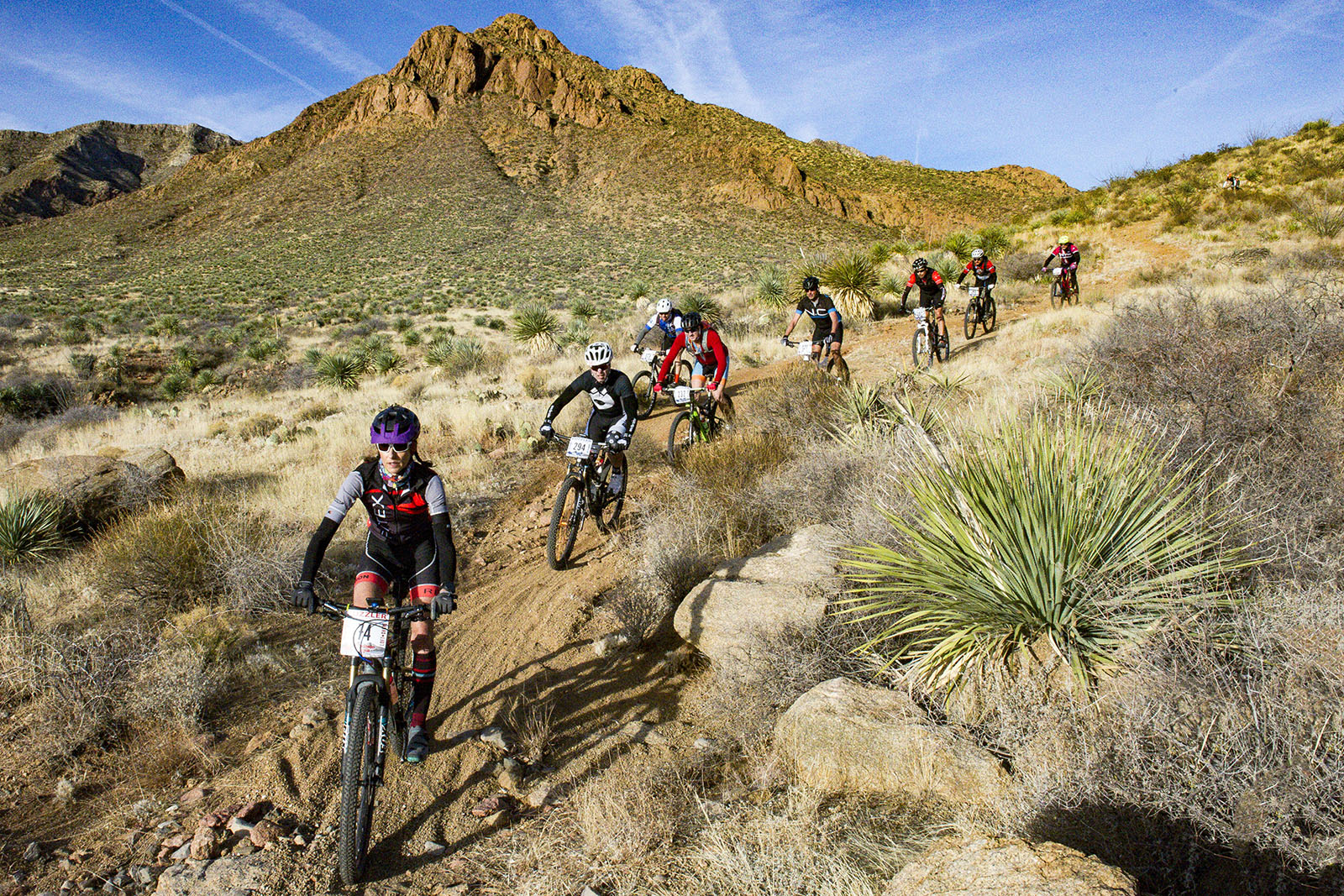 Mountain bikers race down a desert trail in Franklin Mountains State Park, El Paso, Texas.